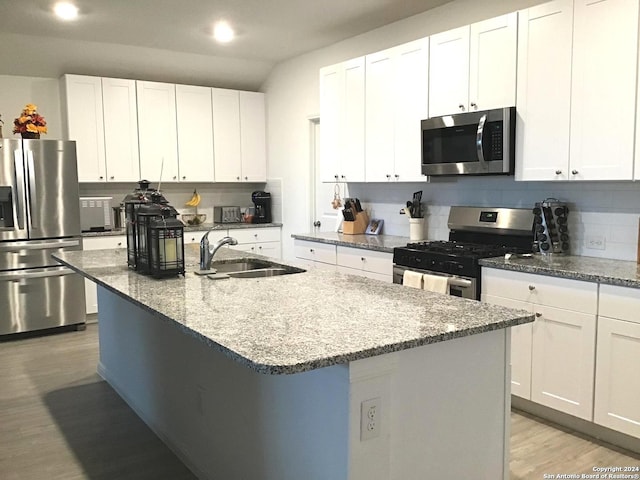 kitchen featuring white cabinets, sink, light hardwood / wood-style flooring, an island with sink, and stainless steel appliances