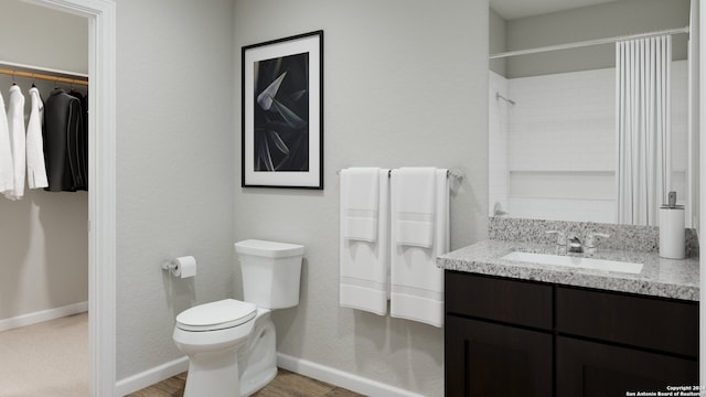 bathroom with hardwood / wood-style floors, vanity, and toilet