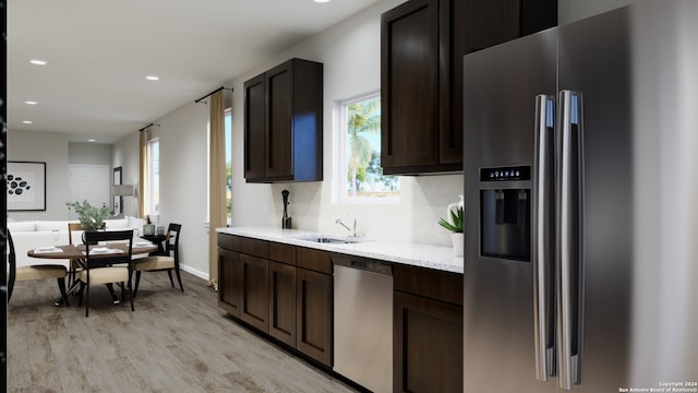 kitchen featuring sink, light hardwood / wood-style flooring, light stone countertops, dark brown cabinetry, and stainless steel appliances