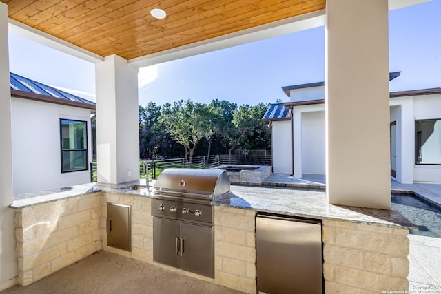 view of patio featuring an outdoor kitchen, grilling area, and fence