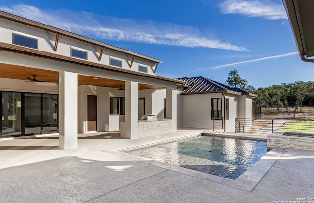 view of swimming pool featuring a fenced in pool, an outdoor kitchen, a ceiling fan, a patio area, and fence