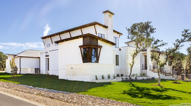 contemporary house with a front yard and stucco siding