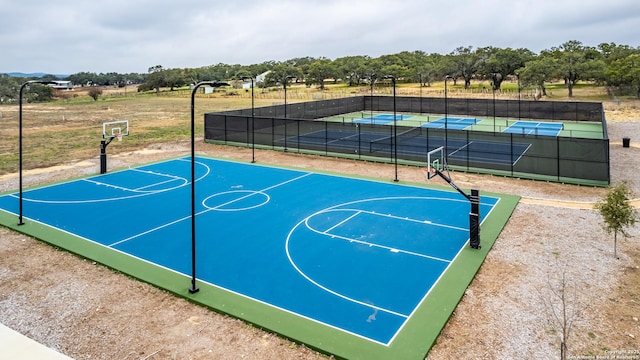 view of basketball court with a tennis court, community basketball court, and fence