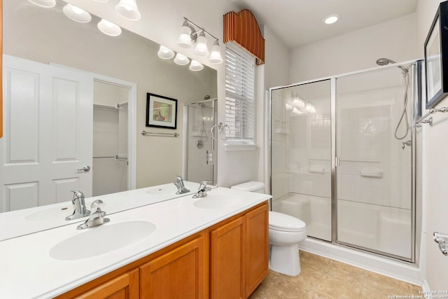 bathroom with tile patterned floors, vanity, toilet, and a shower with shower door