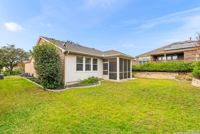 back of house with a sunroom, central air condition unit, and a lawn