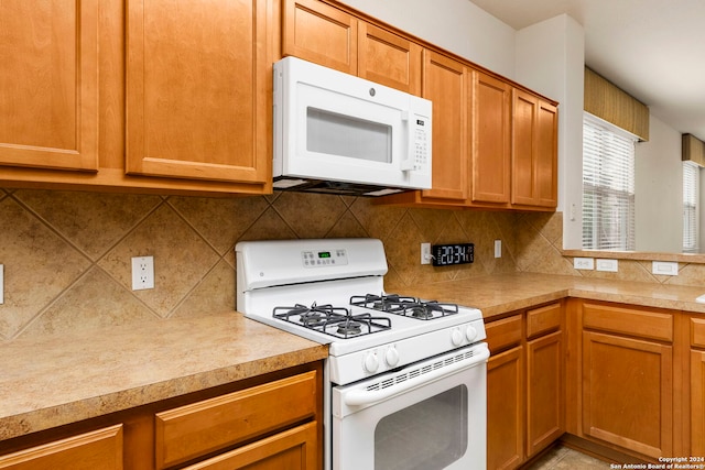 kitchen with decorative backsplash and white appliances