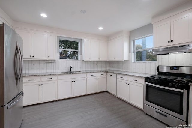 kitchen featuring white cabinetry, sink, stainless steel appliances, and light hardwood / wood-style flooring