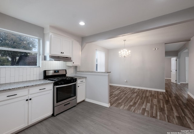 kitchen featuring hardwood / wood-style flooring, white cabinetry, stainless steel gas range oven, and a healthy amount of sunlight