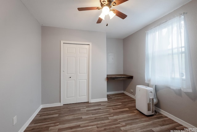 interior space with hardwood / wood-style floors, built in desk, a closet, and ceiling fan