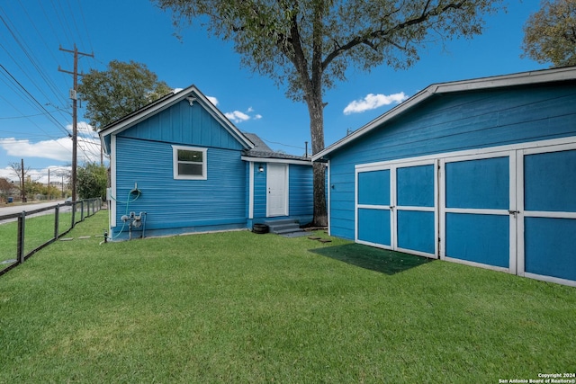 rear view of house with a lawn and a shed