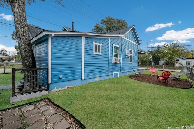 view of side of home with a yard, an AC wall unit, and cooling unit