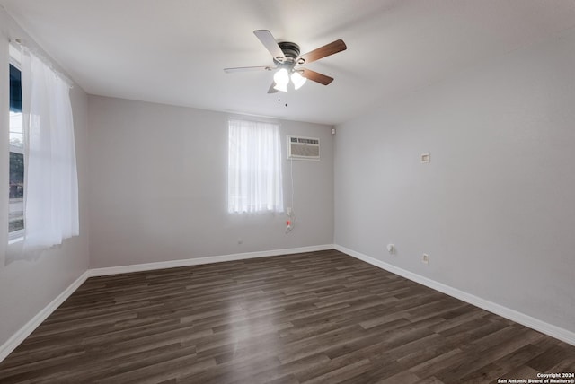 empty room featuring an AC wall unit, ceiling fan, and dark hardwood / wood-style flooring