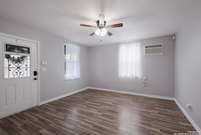 entrance foyer with a wall unit AC, ceiling fan, and dark wood-type flooring