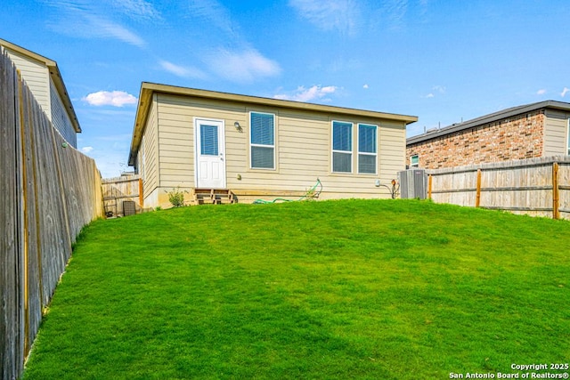 back of house featuring a yard and central AC unit