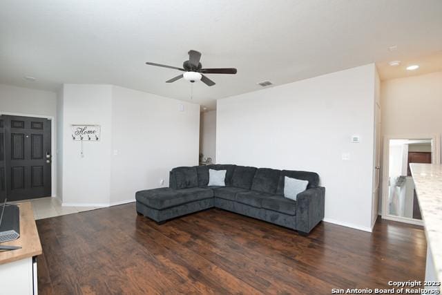 living room with ceiling fan and dark wood-type flooring