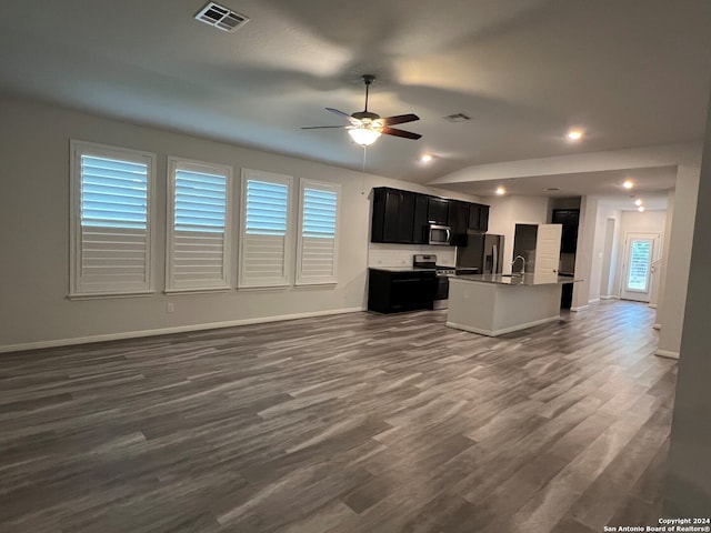 unfurnished living room with dark hardwood / wood-style flooring, a wealth of natural light, and vaulted ceiling