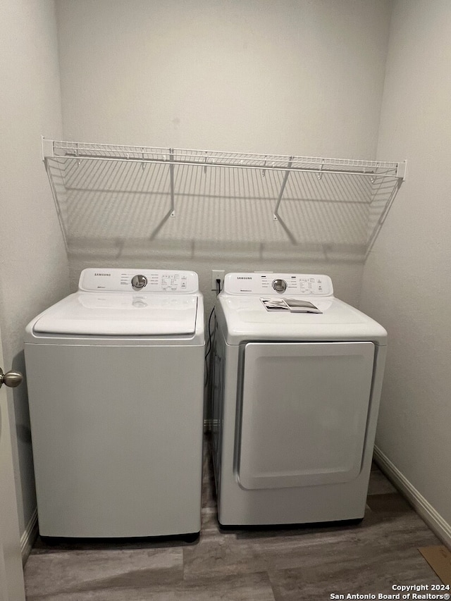 laundry area with washer and clothes dryer and dark hardwood / wood-style floors