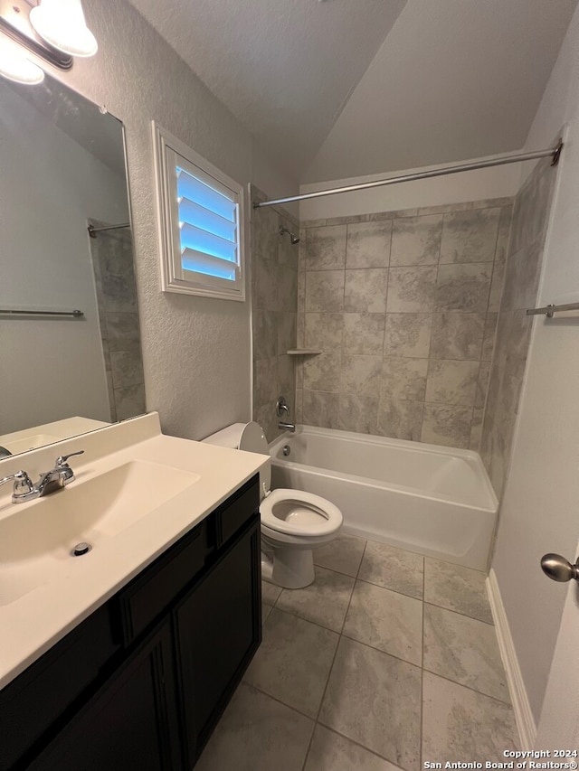 full bathroom featuring tiled shower / bath combo, tile patterned flooring, a textured ceiling, toilet, and vanity