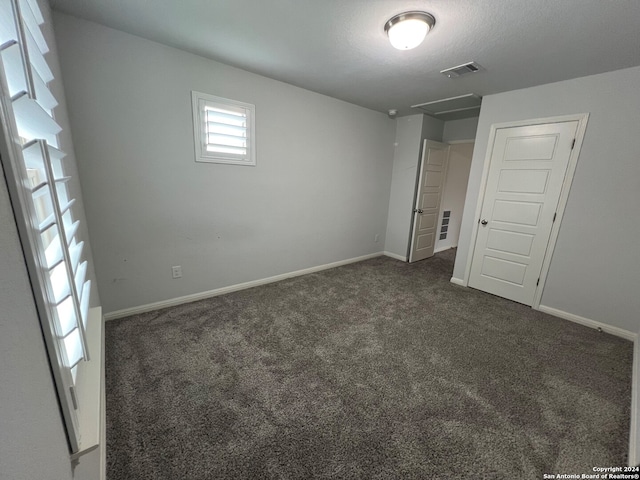 unfurnished bedroom featuring dark carpet