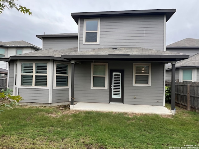 back of property with a lawn and a patio area