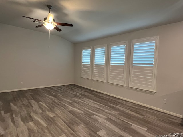 unfurnished room with lofted ceiling, a wealth of natural light, dark wood-type flooring, and ceiling fan