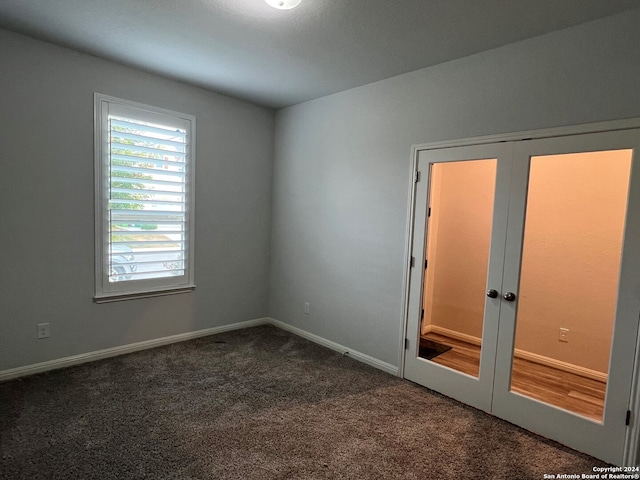 empty room with french doors and dark carpet