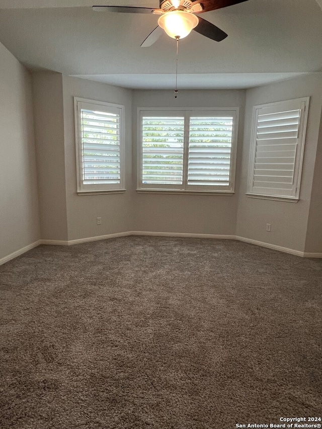 carpeted spare room with ceiling fan