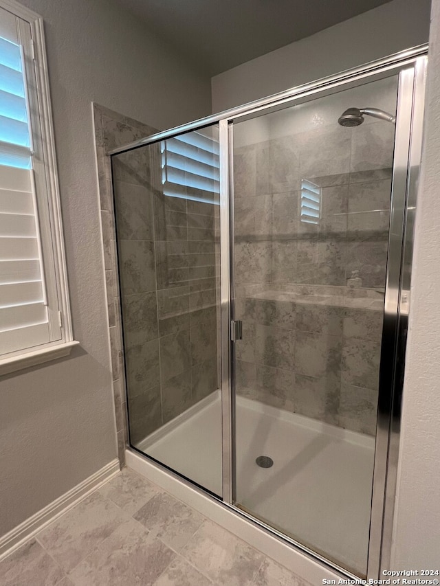 bathroom featuring a shower with shower door