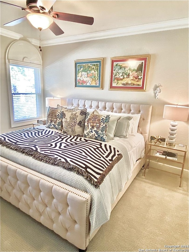 bedroom with ceiling fan, light colored carpet, and crown molding