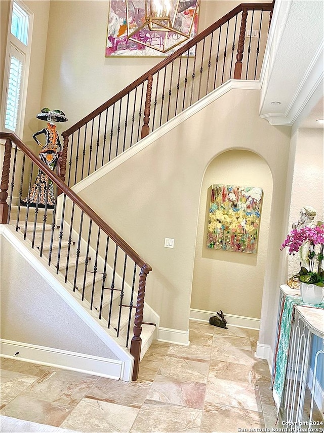 stairway featuring a towering ceiling