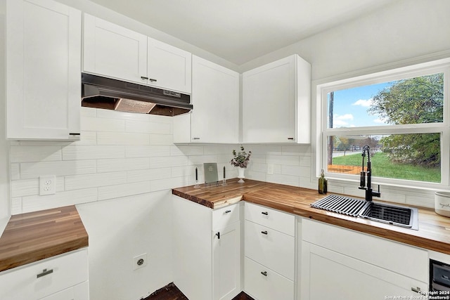 kitchen featuring backsplash, white cabinetry, sink, and wooden counters