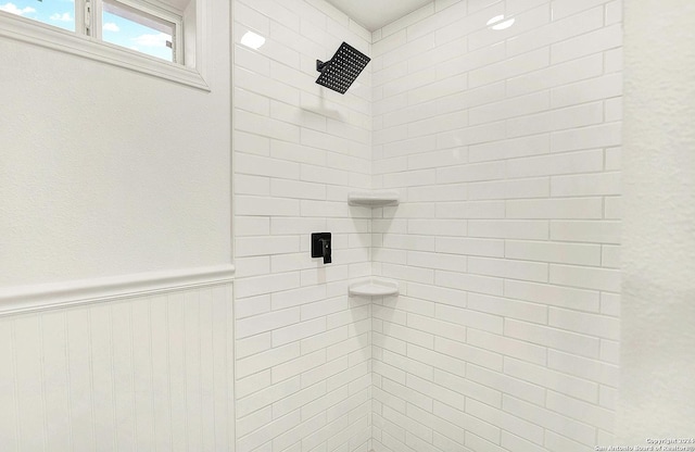 bathroom featuring a tile shower and wooden walls