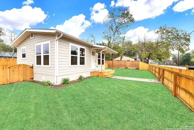 rear view of house featuring a yard