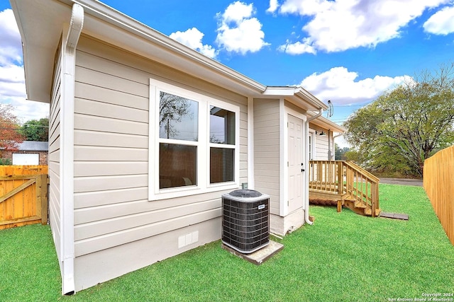 view of side of home with a lawn and cooling unit