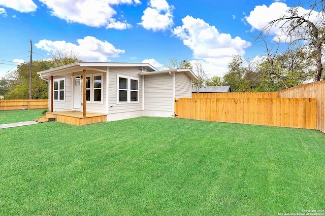 rear view of house featuring a yard