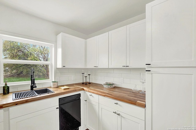 kitchen with butcher block countertops, decorative backsplash, white cabinetry, and sink