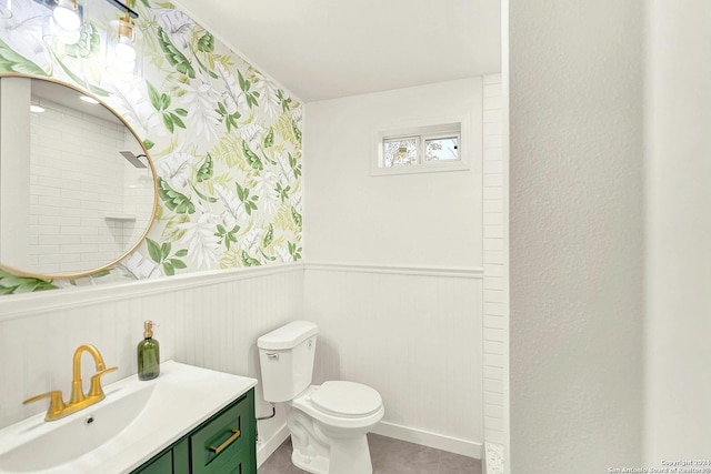 bathroom with vanity, toilet, and a tile shower