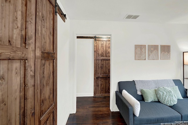 living area with a barn door and dark hardwood / wood-style floors