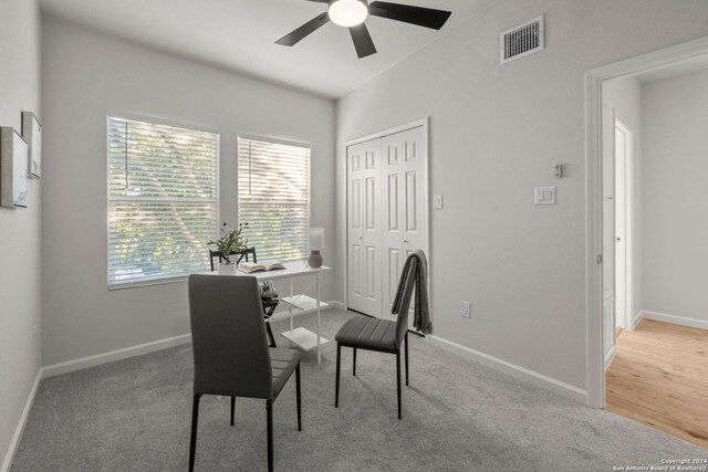 dining space featuring light carpet and ceiling fan