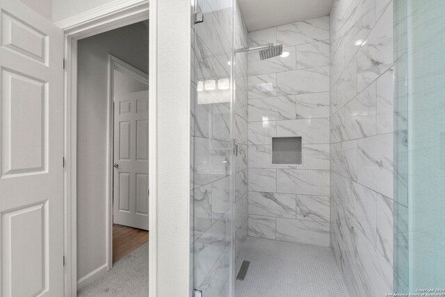 bathroom with hardwood / wood-style floors and a shower with door