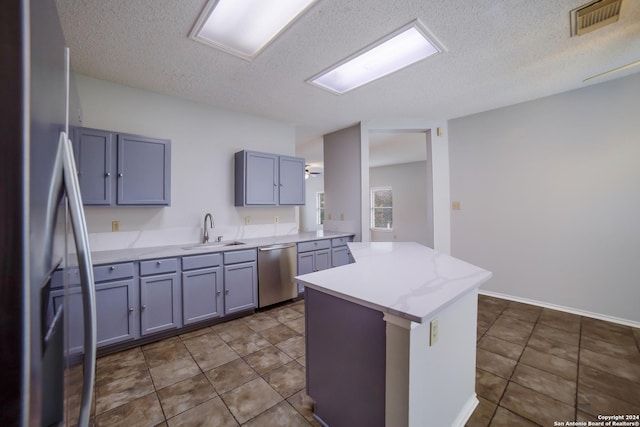 kitchen featuring a textured ceiling, tile patterned flooring, sink, and appliances with stainless steel finishes