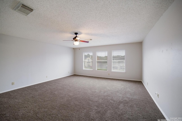 carpeted empty room featuring ceiling fan and a textured ceiling