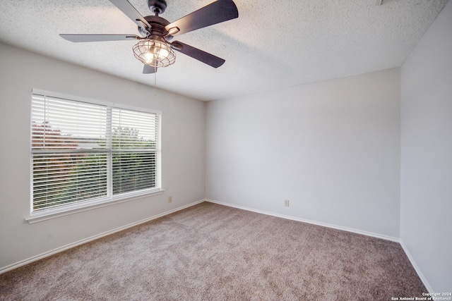 carpeted spare room featuring ceiling fan and a textured ceiling