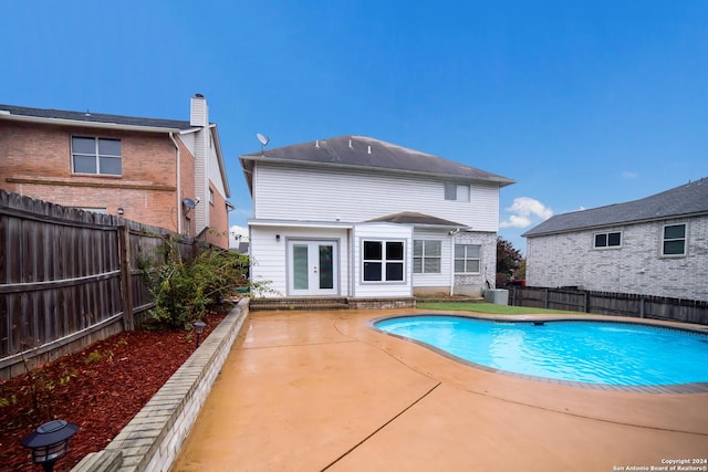 view of swimming pool with french doors and a patio area