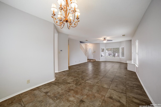 unfurnished room featuring ceiling fan with notable chandelier