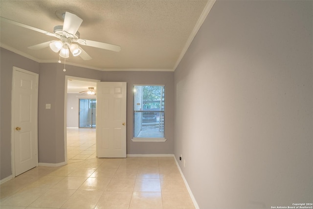 tiled empty room featuring ceiling fan, a textured ceiling, and ornamental molding