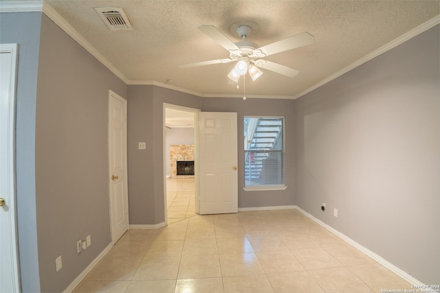 spare room featuring light tile patterned floors, ceiling fan, and crown molding