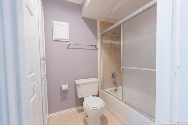 bathroom with tile patterned flooring, enclosed tub / shower combo, and toilet