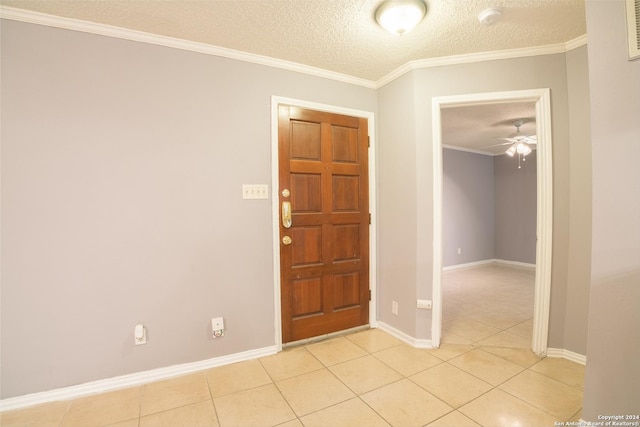 tiled foyer featuring a textured ceiling, ceiling fan, and crown molding