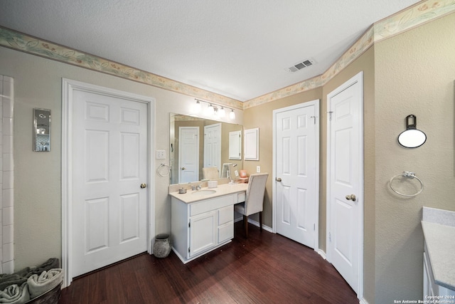 bathroom with vanity, a textured ceiling, and hardwood / wood-style flooring